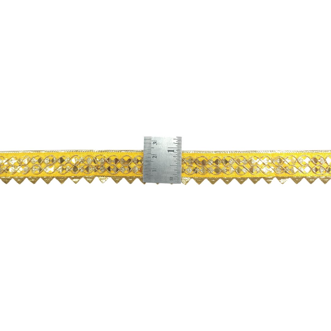 Yellow lace trim with a ruler for scale on a white background